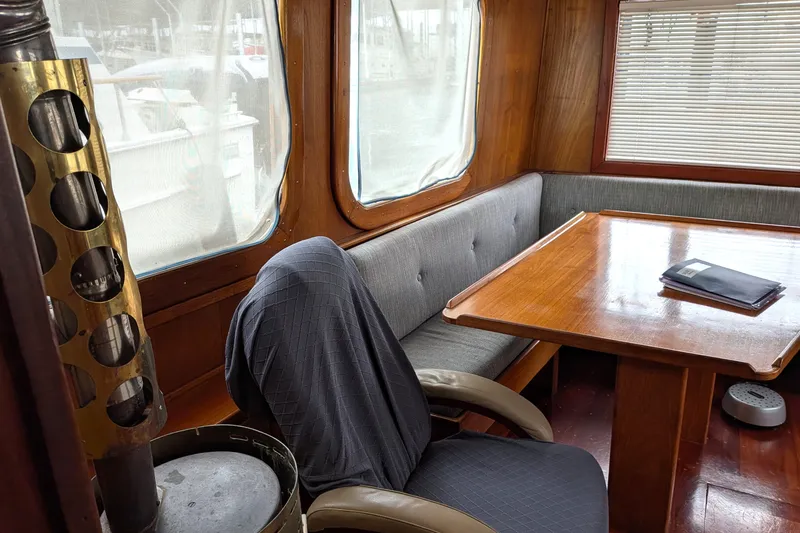 Slide: The Image of Interior of 1981 Custom 43 Pilothouse Trawler with wooden table and cushioned seating. - 31