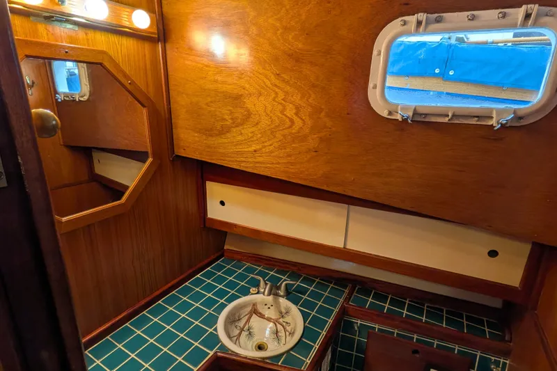 Slide: The Image of Wood-paneled bathroom with nautical porthole, Custom 43 Pilothouse Trawler, 1981. - 51