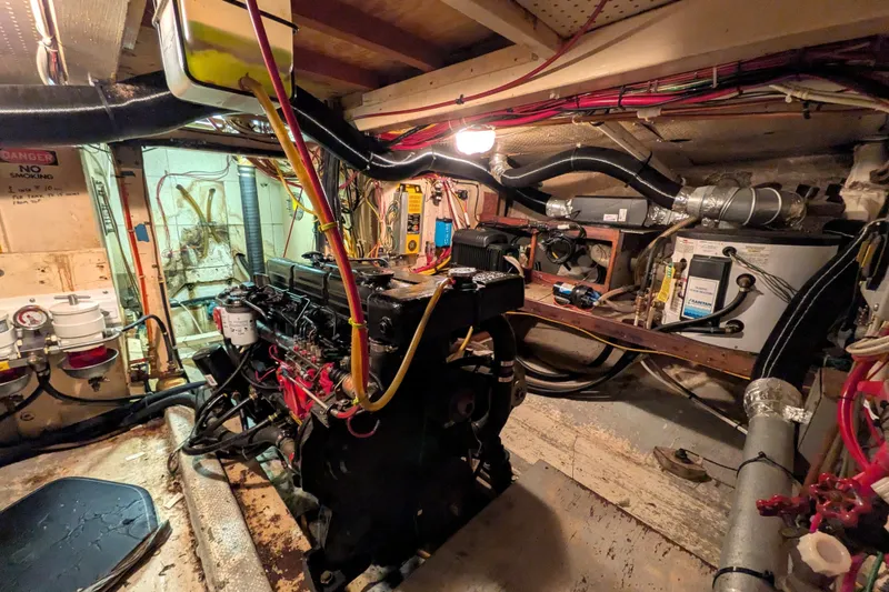 Slide: The Image of Engine room of a 1981 Custom 43 Pilothouse Trawler, showcasing machinery and wiring. - 69