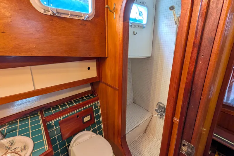 Slide: The Image of 1981 Custom 43 Pilothouse Trawler bathroom with wood accents and tiled shower. - 49
