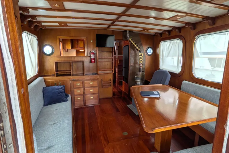 Slide: The Image of Interior of 1981 Custom 43 Pilothouse Trawler with wooden furnishings and seating area. - 40