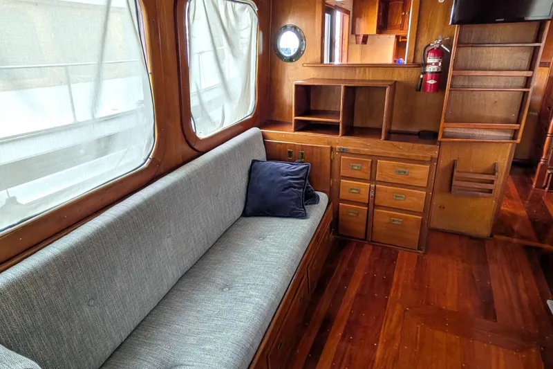Slide: The Image of Interior of 1981 Custom 43 Pilothouse Trawler with wooden cabinetry and cushioned seating. - 32