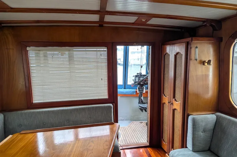 Slide: The Image of Interior of 1981 Custom 43 Pilothouse Trawler with wood paneling and seating area. - 36