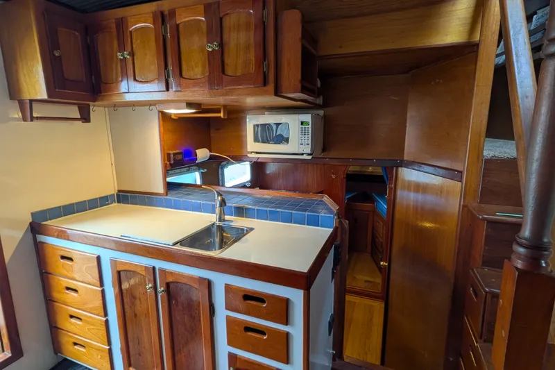 Slide: The Image of 1981 Custom 43 Pilothouse Trawler kitchen with wooden cabinets and modern appliances. - 28