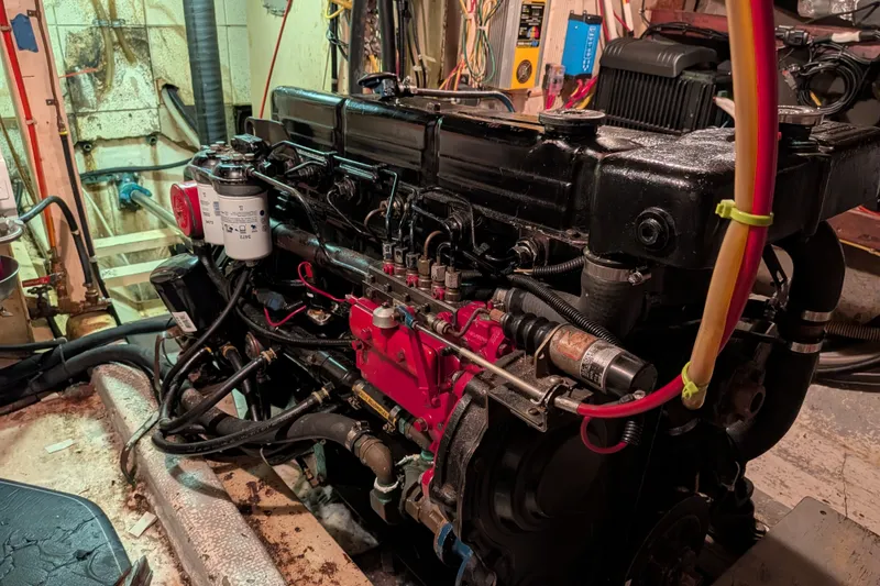 Slide: The Image of Engine room of 1981 Custom 43 Pilothouse Trawler with visible machinery and wiring. - 67