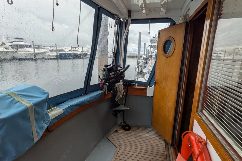 Slide: The Image of 1981 Custom 43 Pilothouse Trawler interior with marina view through rain-speckled windows. - 39