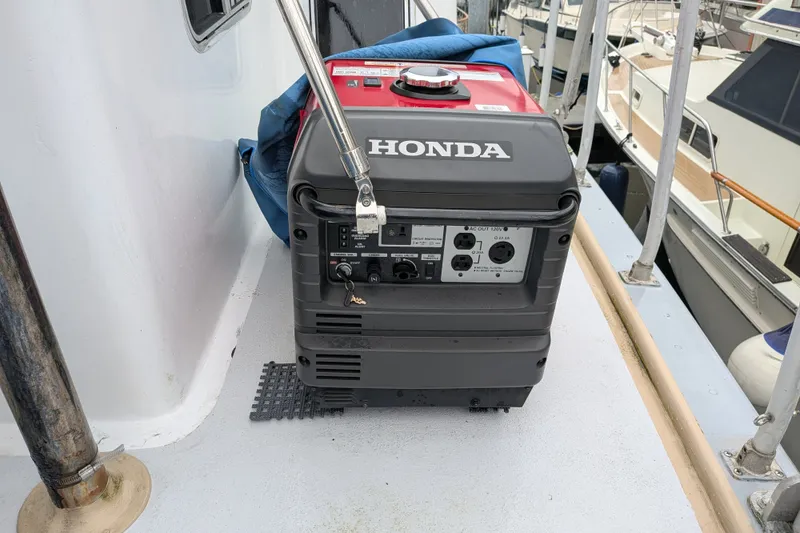 Slide: The Image of Honda generator on 1981 Custom 43 Pilothouse Trawler deck, docked near other boats. - 22