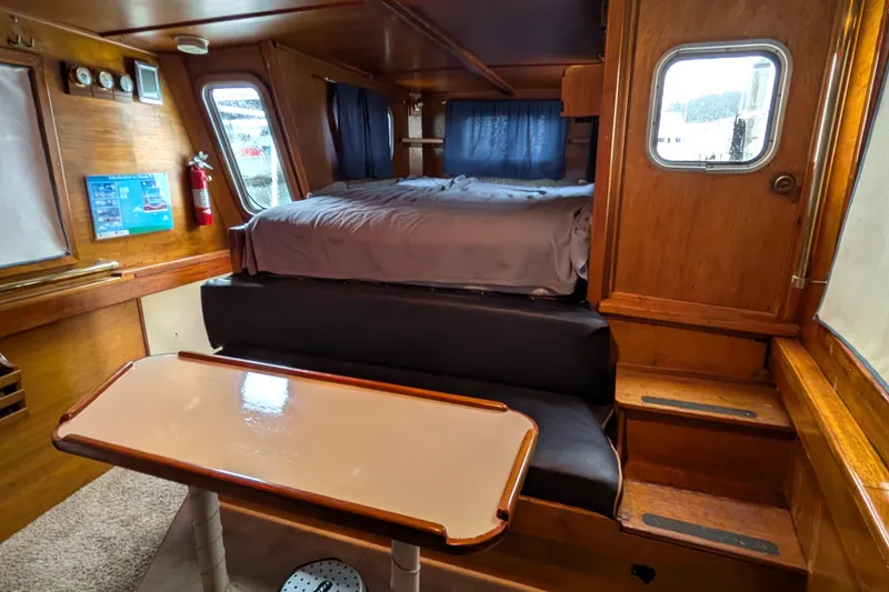 Slide: The Image of Interior of 1981 Custom 43 Pilothouse Trawler with bed, table, and wooden furnishings. - 62