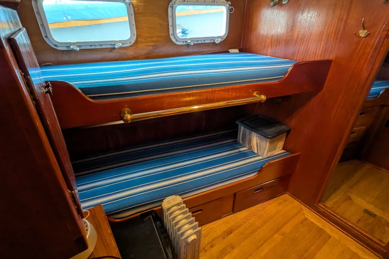 Slide: The Image of Interior of 1981 Custom 43 Pilothouse Trawler with wooden bunk beds and striped cushions. - 44