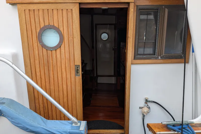 Slide: The Image of Wooden door with porthole on 1981 Custom 43 Pilothouse Trawler. - 23