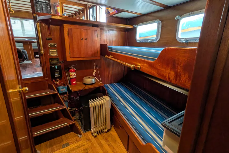 Slide: The Image of Interior of 1981 Custom 43 Pilothouse Trawler with wooden bunk beds and nautical decor. - 47