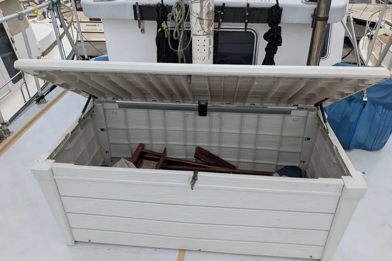 Slide: The Image of Open storage compartment on 1981 Custom 43 Pilothouse Trawler deck, containing wooden items. - 21