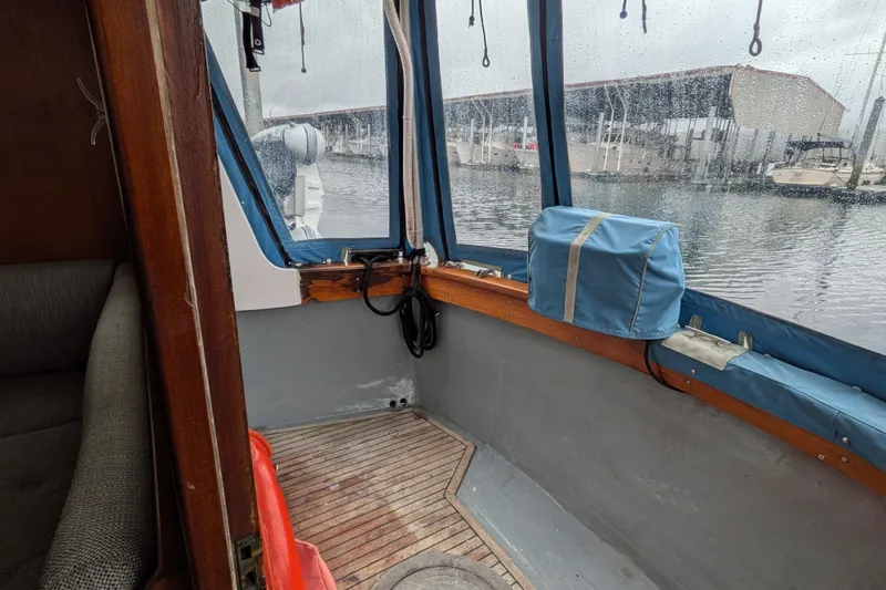 Slide: The Image of Interior view of 1981 Custom 43 Pilothouse Trawler with wooden flooring and marina backdrop. - 38