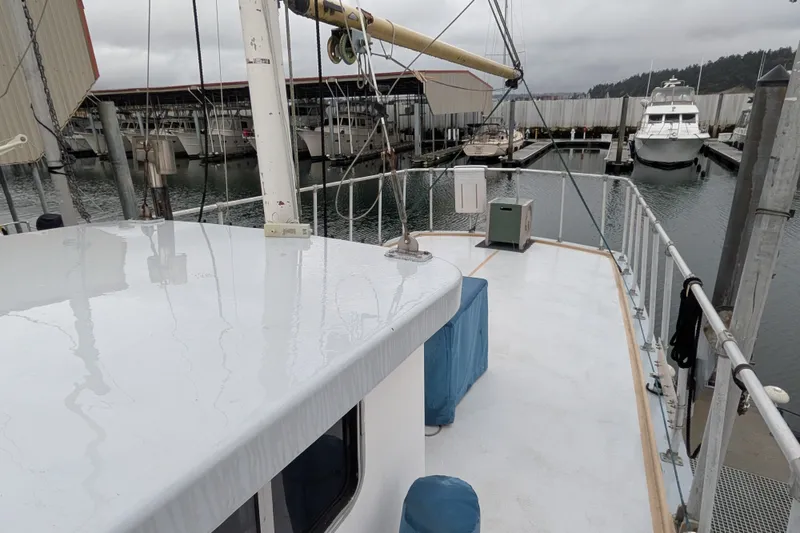 Slide: The Image of 1981 Custom 43 Pilothouse Trawler docked at marina, showcasing deck and railing. - 16