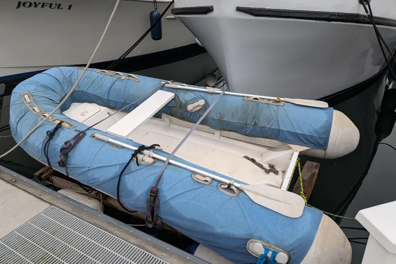 Slide: The Image of Blue inflatable dinghy docked beside a Custom 43 Pilothouse Trawler, 1981 model. - 70