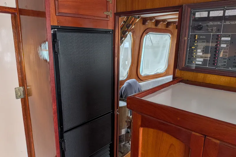Slide: The Image of Interior of 1981 Custom 43 Pilothouse Trawler with control panel and wooden cabinetry. - 27