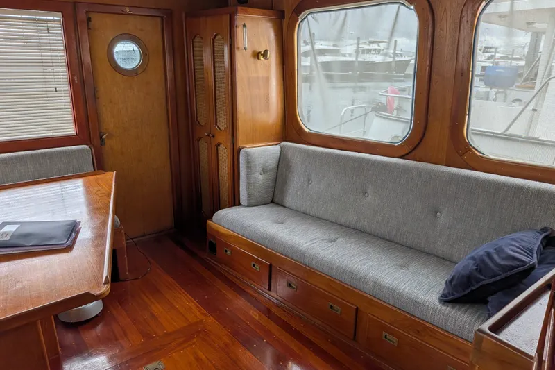 Slide: The Image of Interior of 1981 Custom 43 Pilothouse Trawler with wooden furnishings and gray seating. - 30