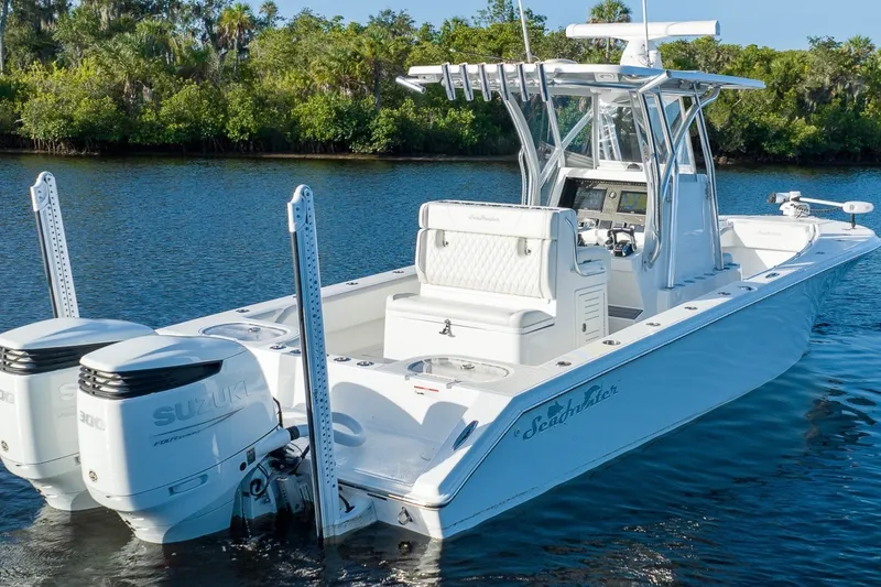 Slide: The Image of 2023 SeaHunter 28 Floridian boat with dual Suzuki engines on a calm waterway. - 29