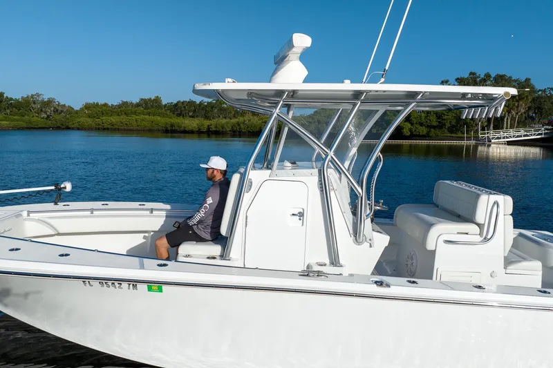 Slide: The Image of 2023 SeaHunter 28 Floridian boat on calm water with a person seated, clear blue sky. - 30