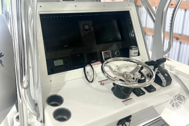 Slide: The Image of 2023 SeaHunter 28 Floridian boat dashboard with steering wheel and navigation controls. - 37