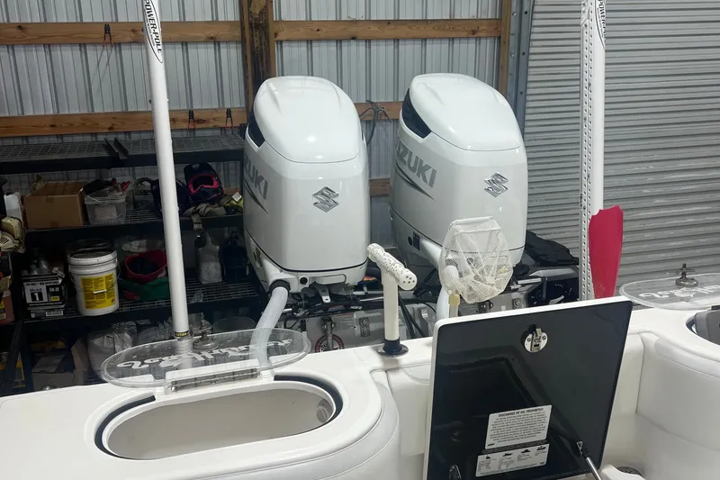Slide: The Image of 2023 SeaHunter 28 Floridian with dual Suzuki outboard engines in a garage setting. - 40