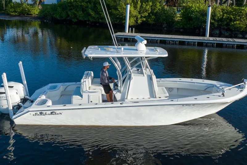 Slide: The Image of 2023 SeaHunter 28 Floridian boat cruising on calm water with lush greenery background. - 20