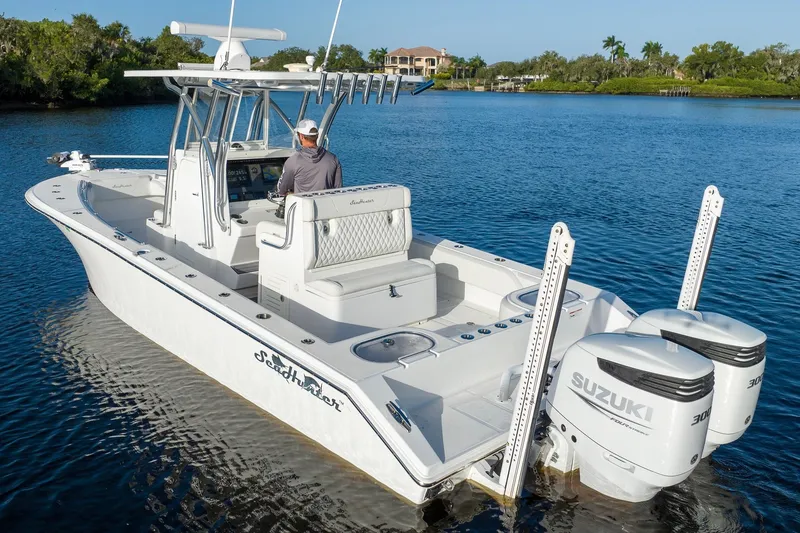 Slide: The Image of 2023 SeaHunter 28 Floridian boat with dual Suzuki engines on a calm waterway. - 19