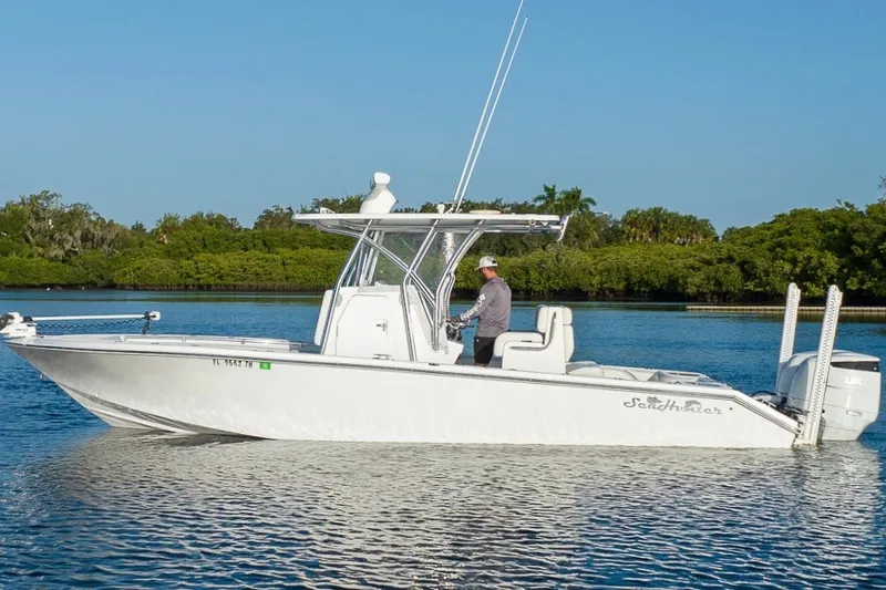 Slide: The Image of 2023 SeaHunter 28 Floridian boat cruising on calm water with lush greenery background. - 14