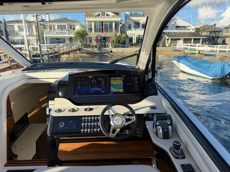 Slide: The Image of The cockpit of a Sea Ray Sundancer 370 Outboard with modern instruments and a view of the harbor. - 35