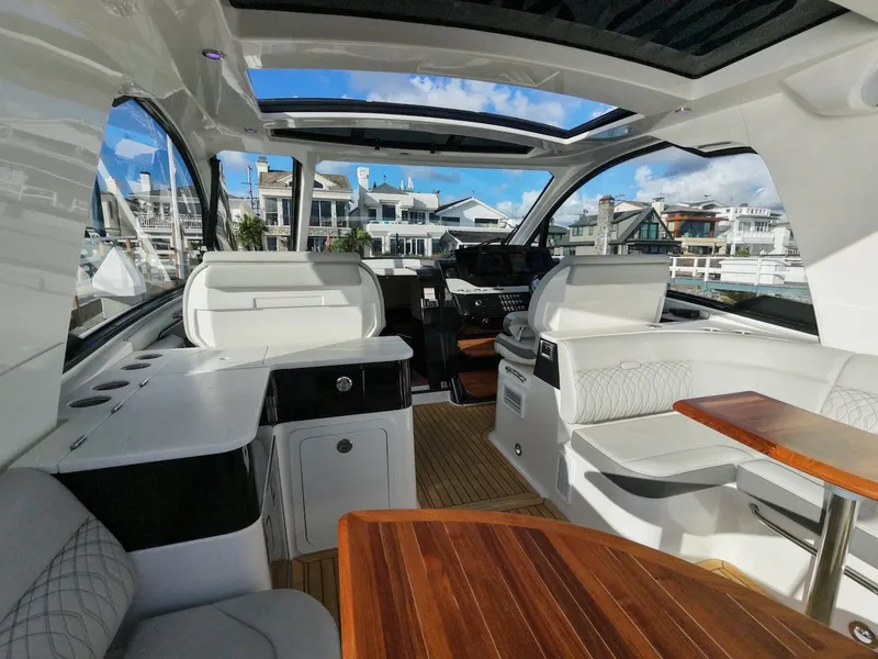 Slide: The Image of Interior of a Sea Ray Sundancer 370 Outboard with sleek wooden tables and modern seating. - 17