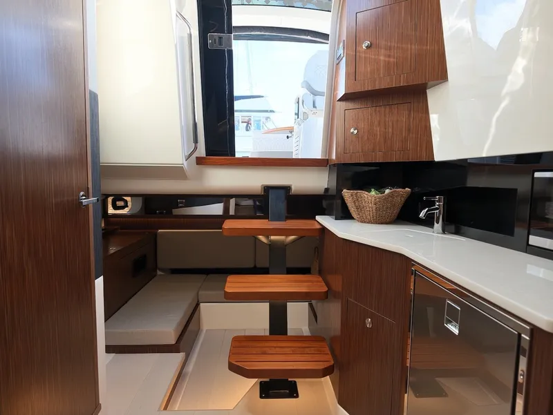 Slide: The Image of Interior of the 2022 Sea Ray Sundancer 370 Outboard with wooden steps and modern kitchen. - 47