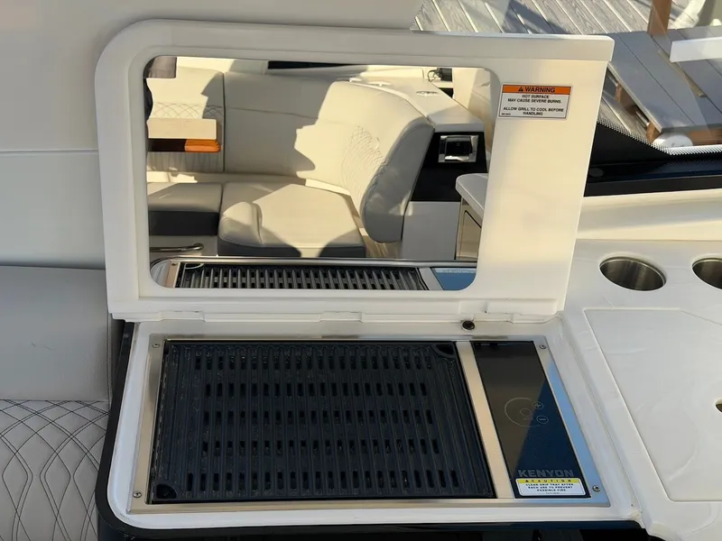 Slide: The Image of A grill on a boat with seating area in the background. - 24