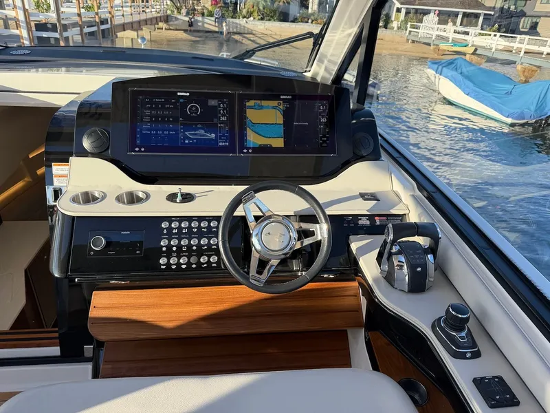 Slide: The Image of The image shows the cockpit of a 2022 Sea Ray Sundancer 370 Outboard with modern navigation systems. - 34
