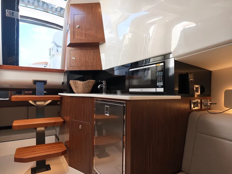 Slide: The Image of Interior of the 2022 Sea Ray Sundancer 370 Outboard with modern kitchen and wood paneling. - 46