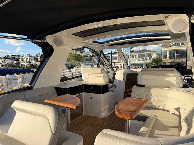 Slide: The Image of The image shows the cockpit of a 2022 Sea Ray Sundancer 370 Outboard with elegant seating and wooden tables. - 22