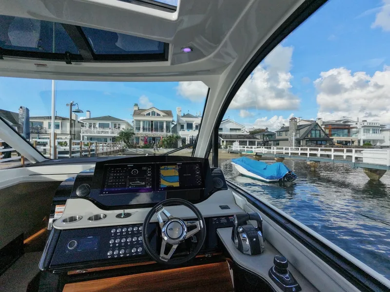Slide: The Image of Interior view of the Sea Ray Sundancer 370 Outboard with modern helm and harbor view. - 31
