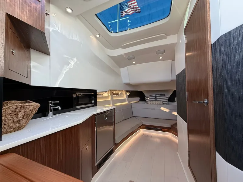 Slide: The Image of Interior of the 2022 Sea Ray Sundancer 370 Outboard with modern kitchen and cozy seating area. - 48