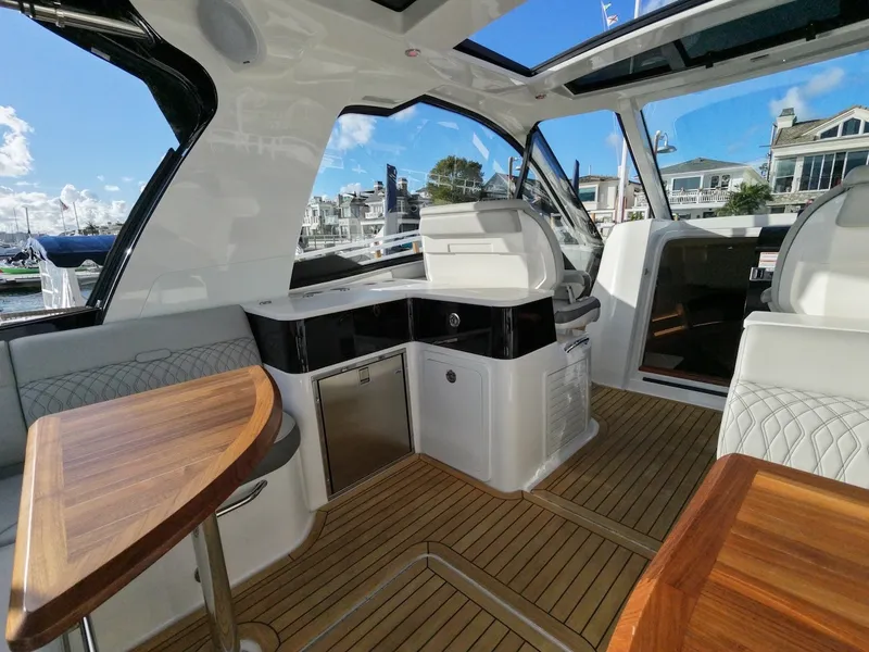 Slide: The Image of Interior of a 2022 Sea Ray Sundancer 370 Outboard with sleek wooden tables and modern amenities. - 18