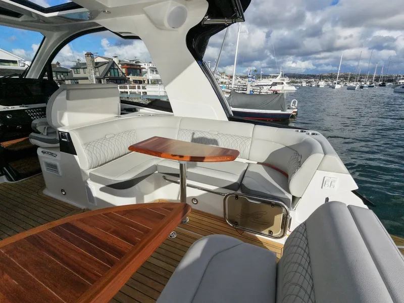 Slide: The Image of The image shows the cockpit of a 2022 Sea Ray Sundancer 370 Outboard with elegant seating and a wooden table. - 16