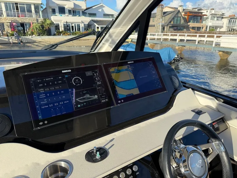 Slide: The Image of The image shows the cockpit of a 2022 Sea Ray Sundancer 370 Outboard with modern navigation screens. - 32