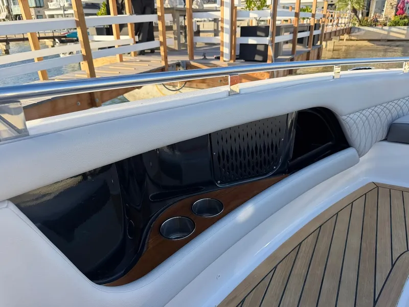 Slide: The Image of The image shows the cockpit of a Sea Ray Sundancer 370 Outboard with sleek wood accents and cup holders. - 43