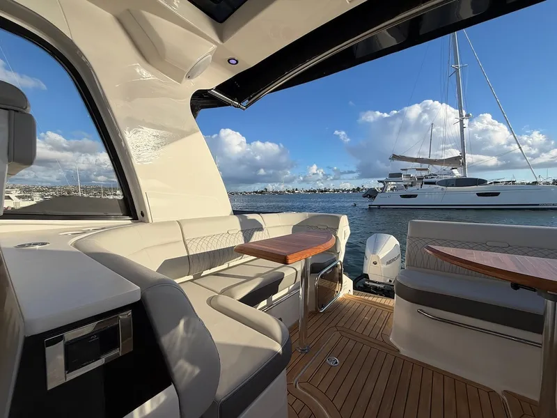 Slide: The Image of Interior view of a 2022 Sea Ray Sundancer 370 Outboard with luxurious seating and wooden tables. - 20