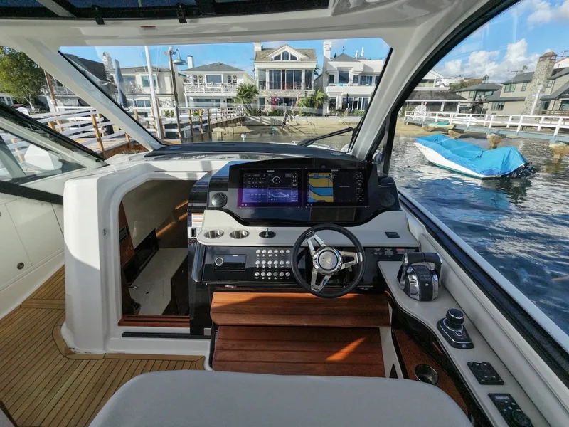 Slide: The Image of The cockpit of the 2022 Sea Ray Sundancer 370 Outboard features a modern helm with digital display. - 30