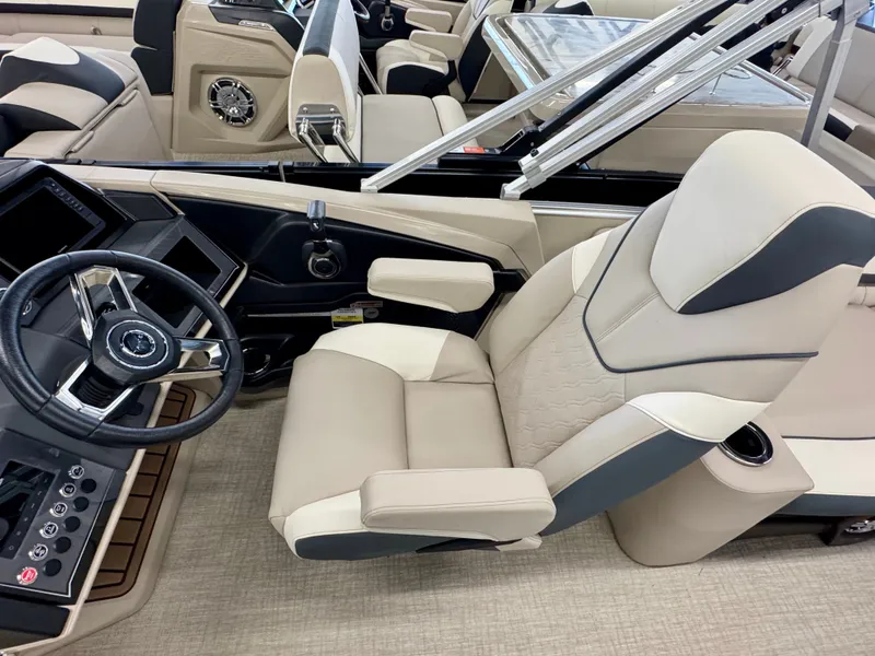 Slide: The Image of The image shows the helm of a 2025 Tahoe Cascade 2385 QLS with beige and gray seating. - 13
