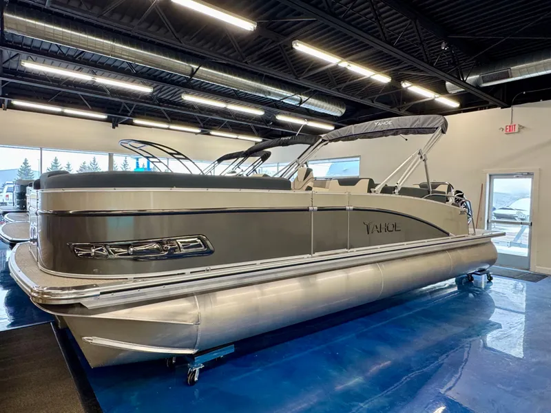 Slide: The Image of The image shows a 2025 Tahoe Cascade 2385 QLS pontoon boat in a showroom. - 1