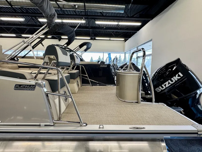 Slide: The Image of The image shows a modern pontoon boat with Suzuki outboard motors in a showroom. - 3