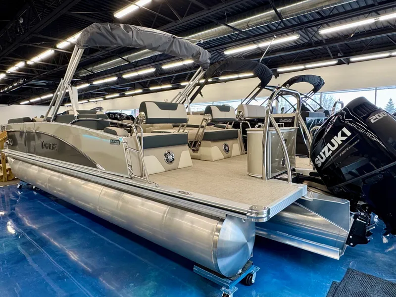 Slide: The Image of The image shows a 2025 Tahoe Cascade 2385 QLS pontoon boat with a Suzuki outboard motor. - 2