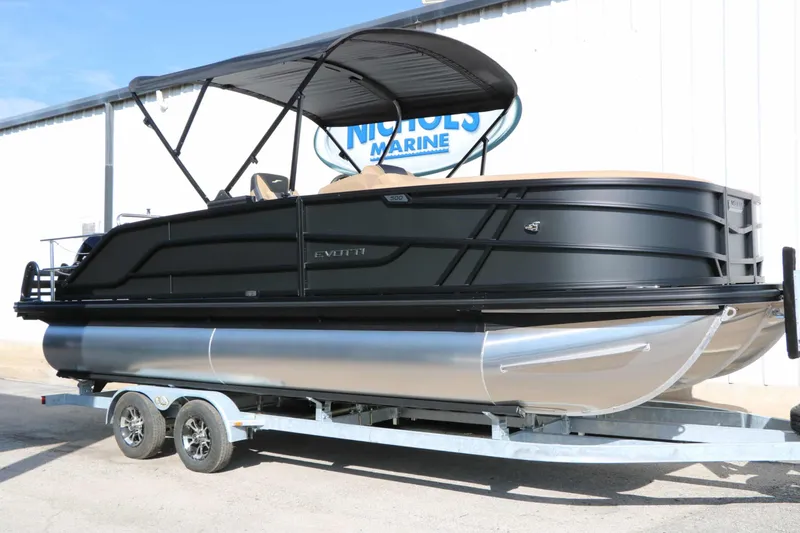 Slide: The Image of The image shows an Evotti 521 CS Tri Toon boat on a trailer. It features a sleek black design and a canopy. - 5