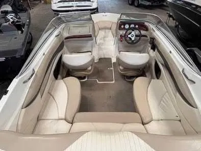 Slide: The Image of Interior view of a 2006 Glastron GX 205 boat with beige seating and steering wheel. - 1