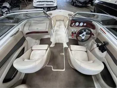 Slide: The Image of Interior view of a Glastron GX 205 boat with two white seats and a helm station. - 2